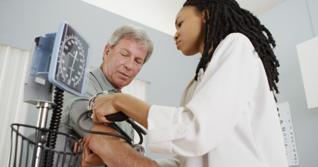 Nurse taking blood pressure an elderly man