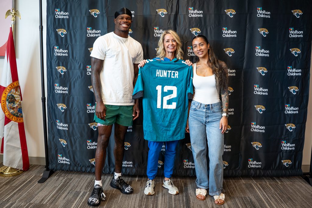 Travis and Leanna Hunter pictured with a nurse holding a NFL Hunter jersey. 